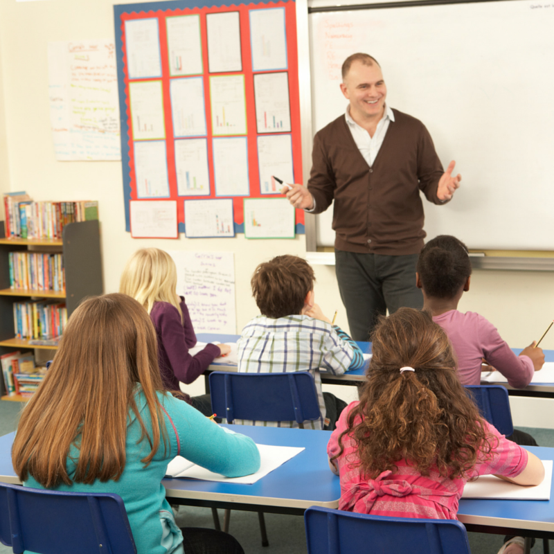 A teacher communicating with children in a classroom.