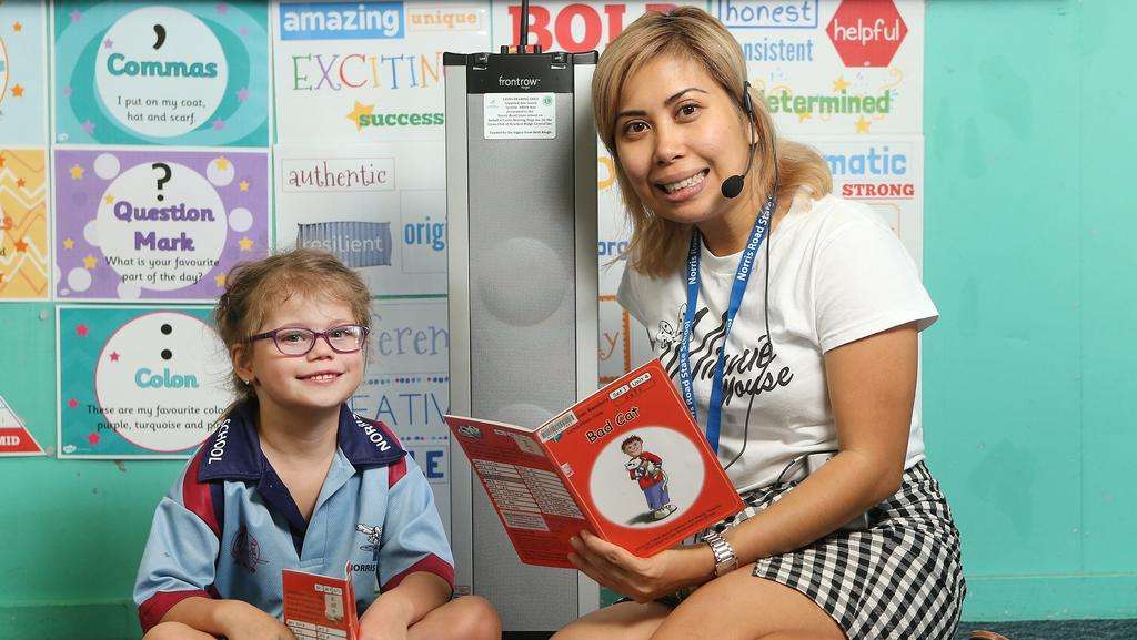 Norris Road State School teacher Rea Real (right) reads to student Maria Chilton, 6, through the school’s new Sound Field System which makes hearing the teacher in a classroom easier for students, especially those with hearing impairments. PICTURE: AAP/Jono Searle